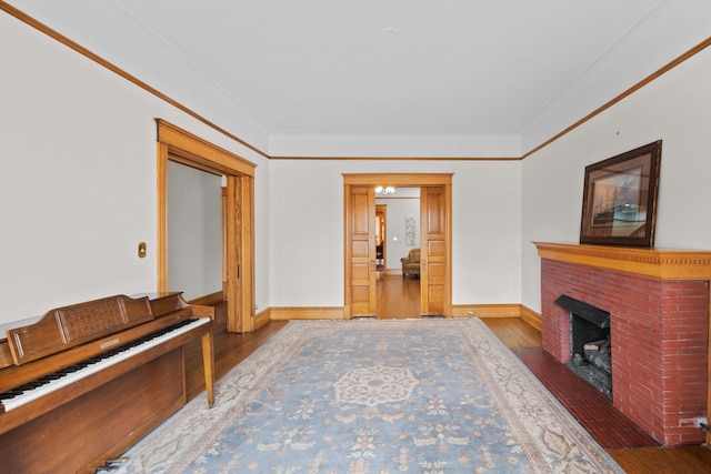 living area with ornamental molding, baseboards, and wood finished floors