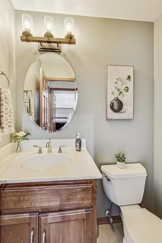 half bathroom featuring toilet and vanity