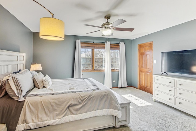 bedroom with light colored carpet, baseboards, and a ceiling fan