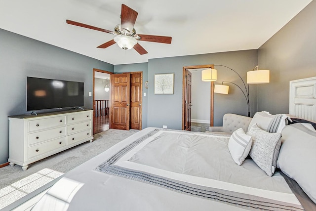 bedroom with a ceiling fan, light colored carpet, and baseboards