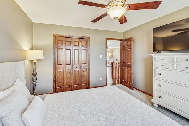 bedroom with a ceiling fan, light colored carpet, baseboards, and a closet