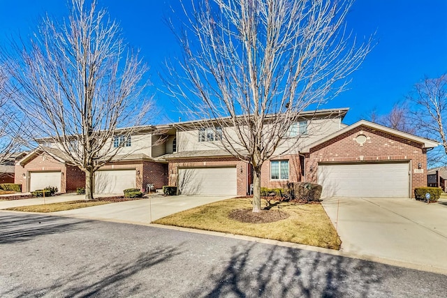 view of front facade featuring brick siding, an attached garage, and driveway