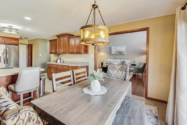 dining room featuring light tile patterned floors, a chandelier, and baseboards