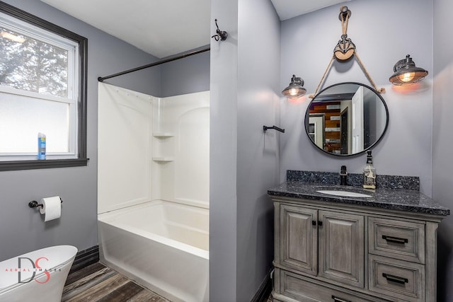 full bathroom featuring washtub / shower combination, toilet, wood finished floors, and vanity