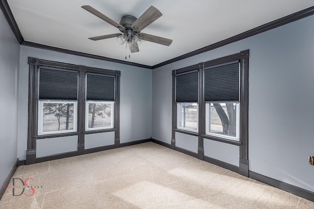 unfurnished room with carpet floors, ceiling fan, baseboards, and crown molding