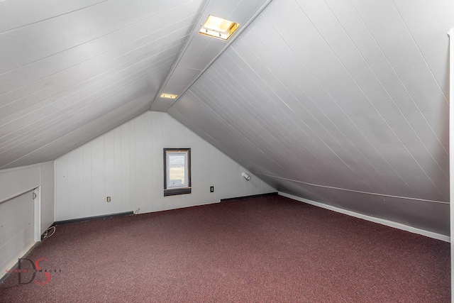 additional living space featuring vaulted ceiling and carpet