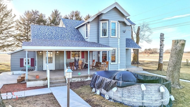 view of front of house with a shingled roof and a porch