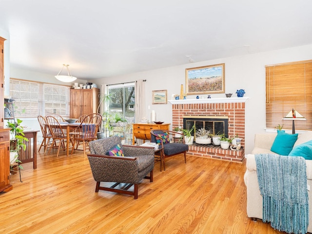 living area with light wood-style floors and a brick fireplace