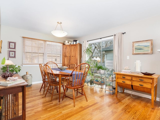 dining room featuring light wood-type flooring and baseboards