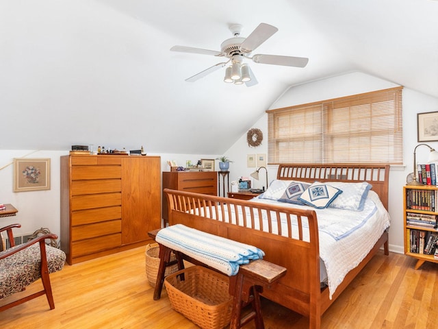 bedroom with vaulted ceiling and light wood-style floors