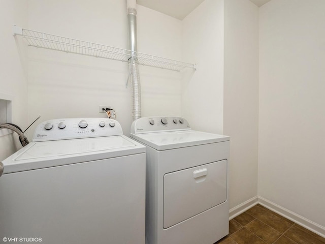 laundry room with laundry area, washing machine and dryer, and baseboards