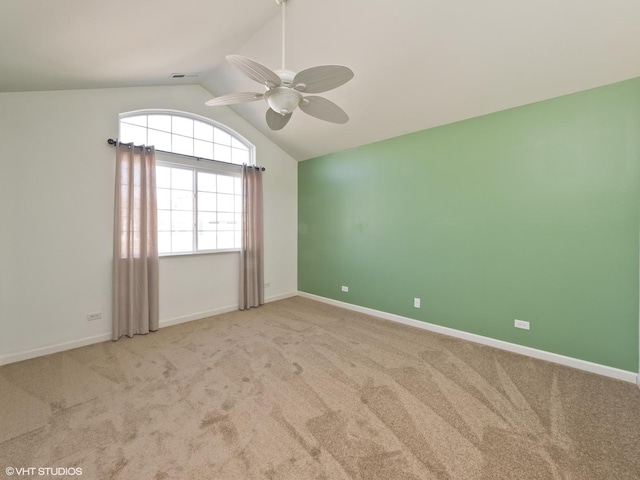 carpeted spare room with lofted ceiling, a ceiling fan, and baseboards