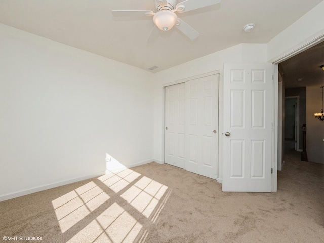 unfurnished bedroom featuring a closet, baseboards, carpet, and a ceiling fan