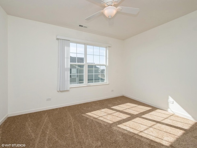 spare room with baseboards, visible vents, carpet floors, and ceiling fan