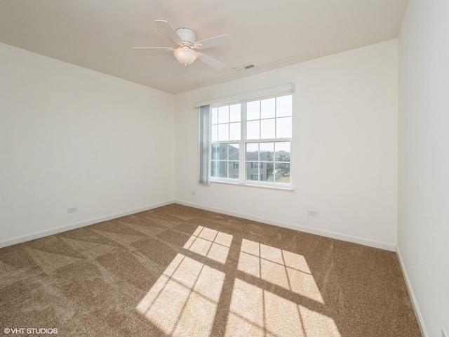 empty room featuring visible vents, baseboards, carpet flooring, and a ceiling fan