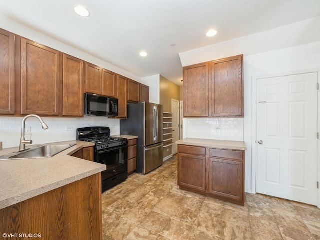 kitchen with recessed lighting, a sink, black appliances, light countertops, and tasteful backsplash