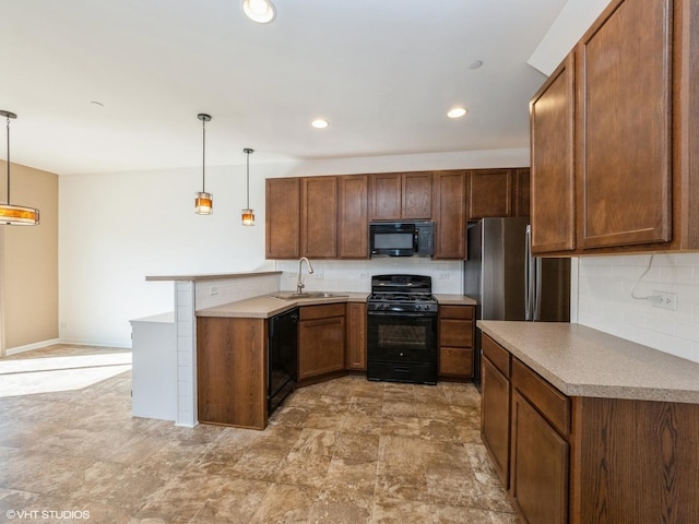 kitchen with a peninsula, a sink, black appliances, decorative light fixtures, and tasteful backsplash