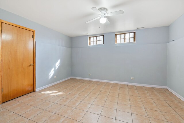 basement with visible vents, baseboards, and ceiling fan