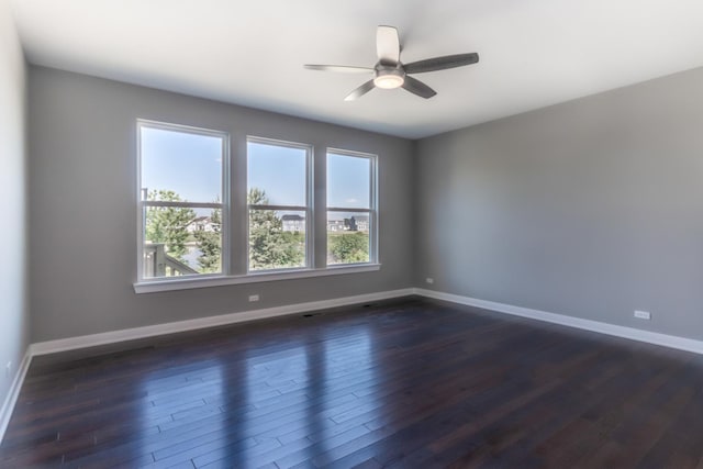 unfurnished room with dark wood-type flooring, ceiling fan, and baseboards