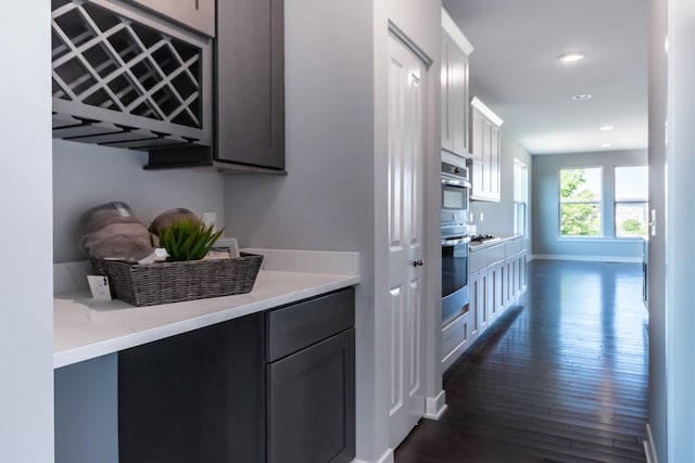 interior space with double oven, recessed lighting, baseboards, light countertops, and dark wood finished floors