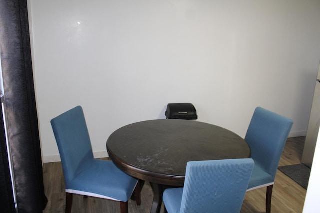 dining area featuring baseboards and wood finished floors