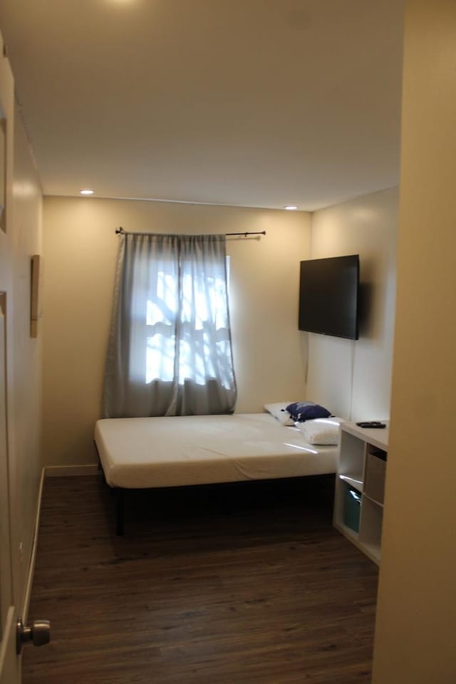 bedroom with baseboards, wood finished floors, and recessed lighting