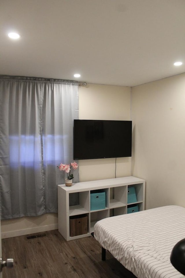 bedroom with baseboards, wood finished floors, visible vents, and recessed lighting