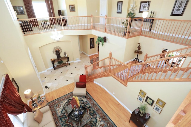 interior space featuring stairs, a high ceiling, and baseboards