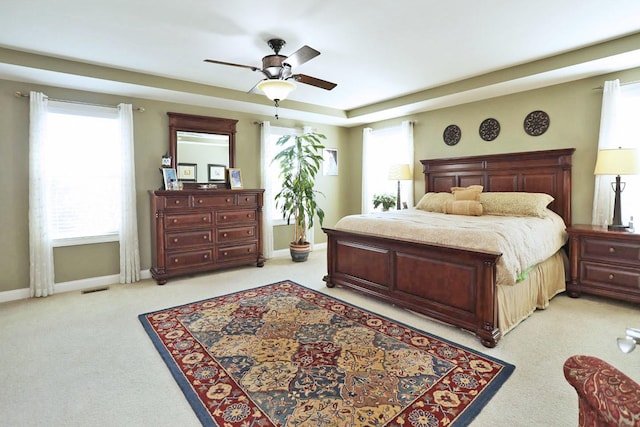 bedroom with baseboards, visible vents, a ceiling fan, and light colored carpet