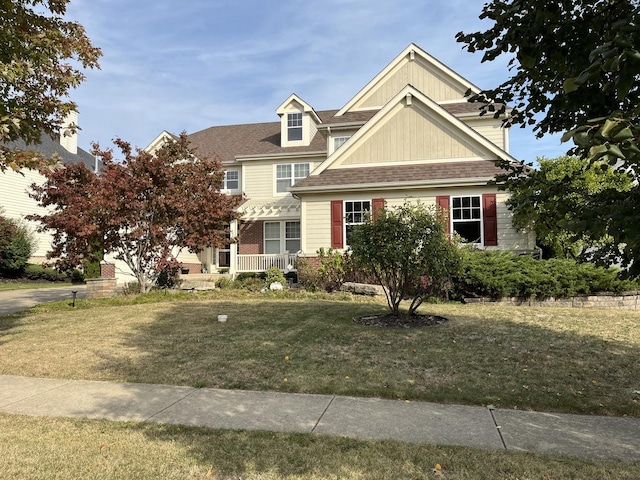 view of front of home featuring a front lawn and roof with shingles