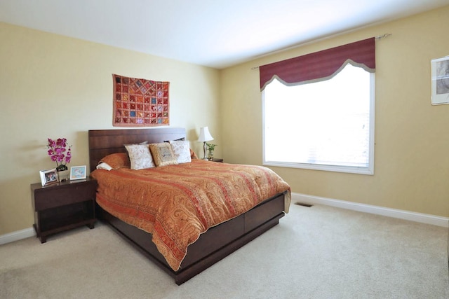 bedroom with carpet floors, visible vents, and baseboards