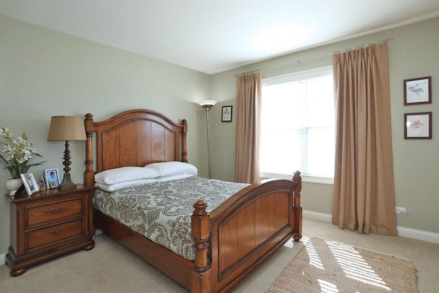 bedroom featuring light colored carpet and baseboards