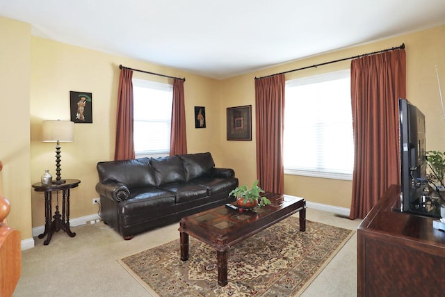 living room featuring light carpet and baseboards