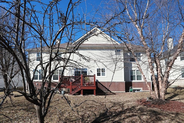 back of house with a deck, brick siding, and stairway