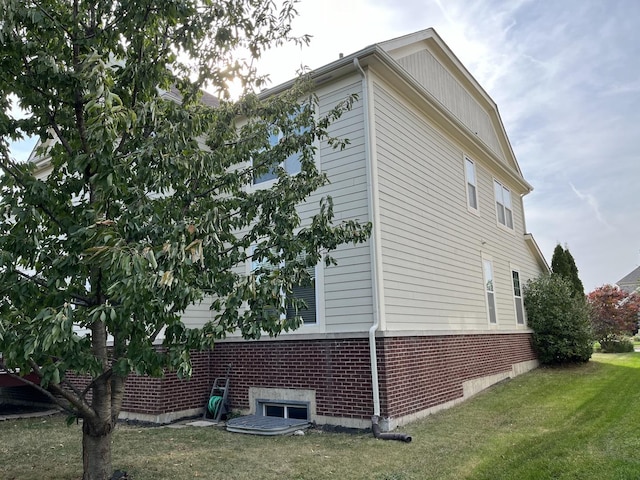 view of side of property with a yard and brick siding