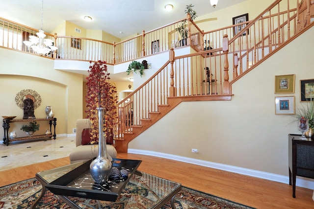 living area with a notable chandelier, wood finished floors, and baseboards