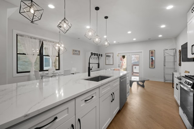 kitchen with stainless steel appliances, light wood-type flooring, a sink, and recessed lighting