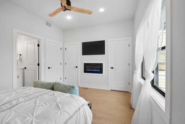 bedroom featuring visible vents, ceiling fan, ensuite bathroom, light wood-style floors, and recessed lighting