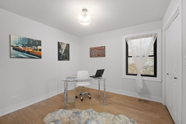 office featuring wood finished floors, visible vents, and baseboards