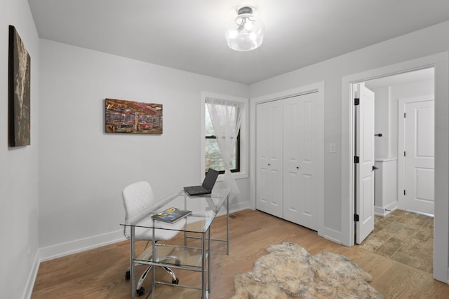 office space with light wood-style flooring and baseboards