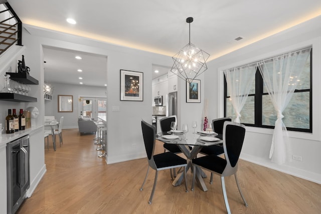 dining area with a dry bar, beverage cooler, baseboards, light wood-style floors, and recessed lighting