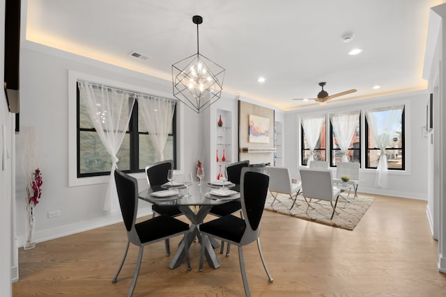 dining space with visible vents, light wood-style flooring, and baseboards