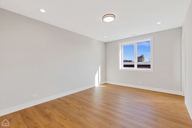 empty room featuring light wood-style flooring, baseboards, and recessed lighting