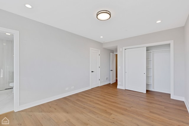 unfurnished bedroom featuring ensuite bathroom, recessed lighting, light wood-style flooring, and baseboards