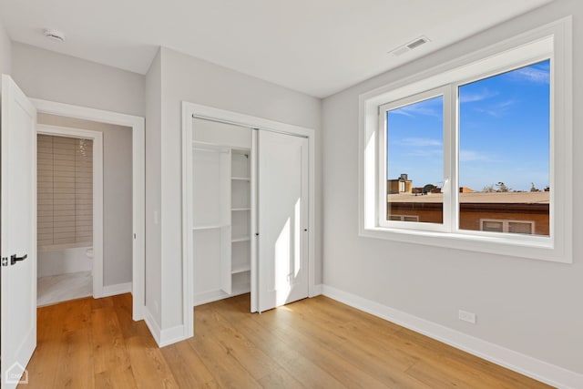 unfurnished bedroom featuring light wood finished floors, visible vents, and baseboards