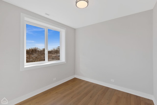 unfurnished room featuring baseboards and wood finished floors