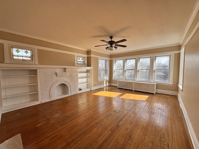 unfurnished living room with plenty of natural light, radiator heating unit, a fireplace, and hardwood / wood-style flooring