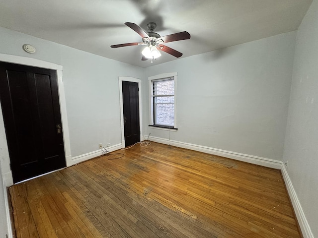 unfurnished bedroom with ceiling fan, wood-type flooring, and baseboards