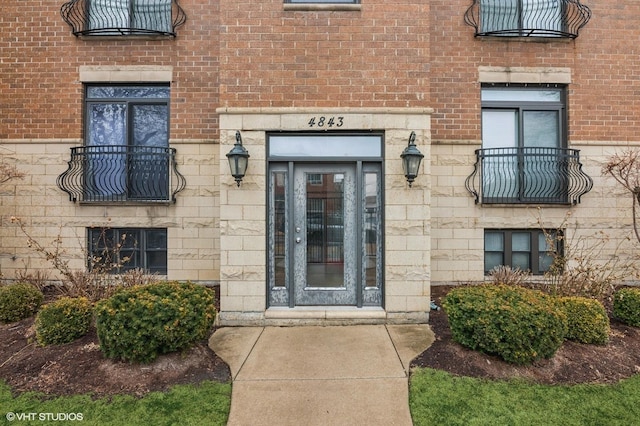 doorway to property with stone siding and brick siding