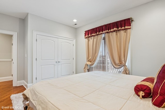 bedroom featuring recessed lighting, a closet, visible vents, wood finished floors, and baseboards